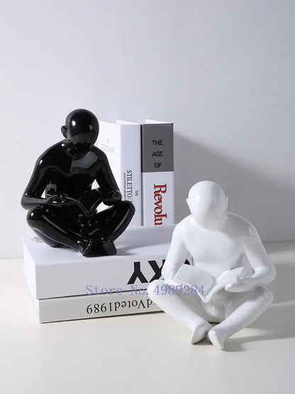 Glossy black and white ceramic figurines of seated human forms by Decorbites creative ceramics for living room decor