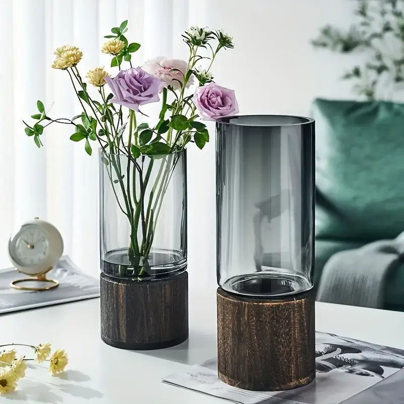 Two creative retro glass vases with dark wood bases and purple and yellow flowers for living room decor