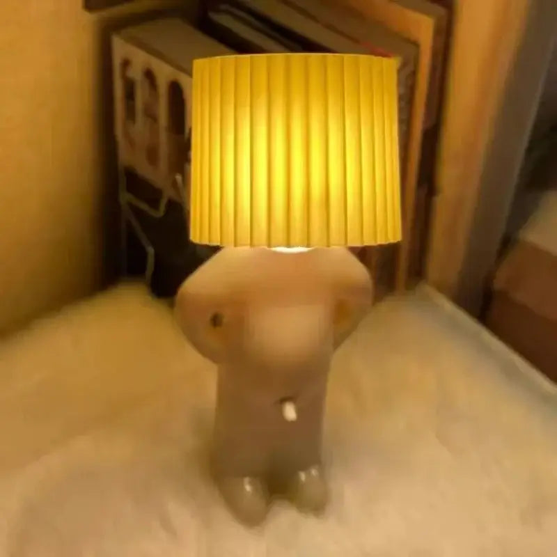 Beige ceramic creative table lamp with pleated yellow shade shaped as anthropomorphic figure for bedside lighting