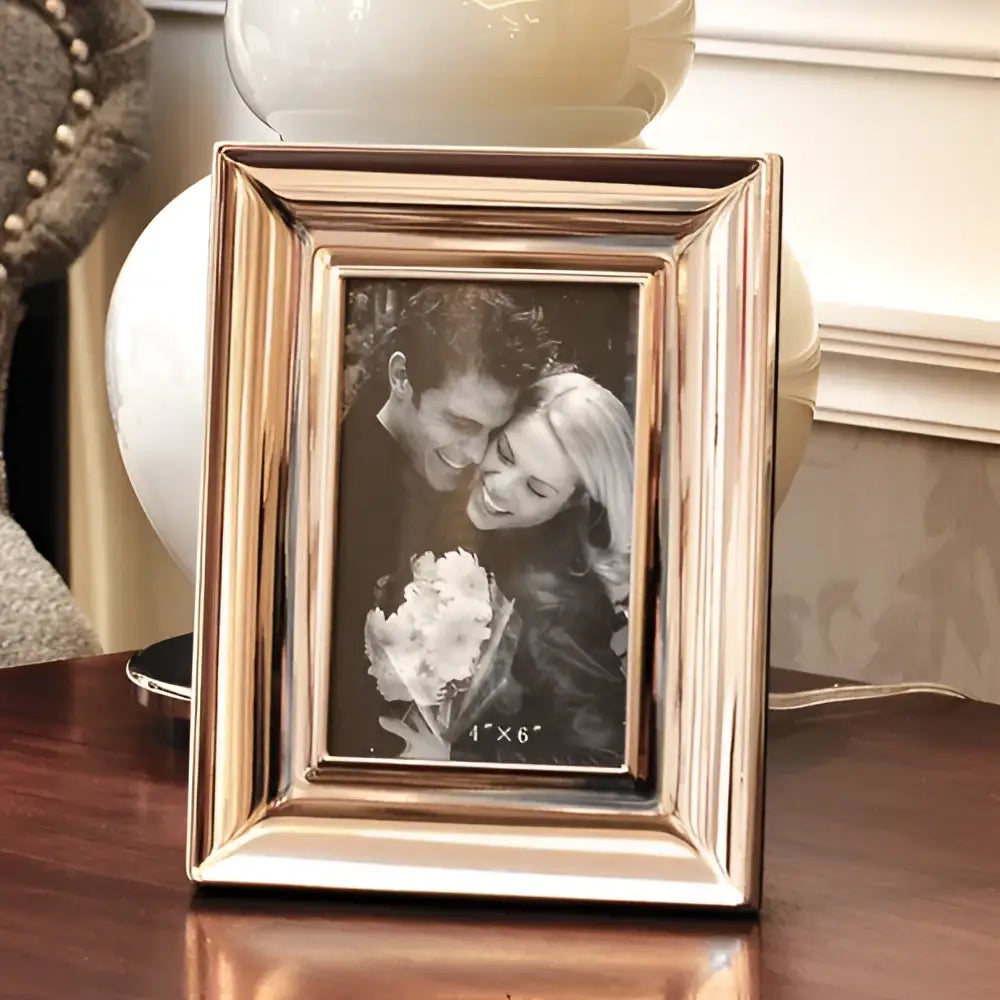 A rectangular brushed gold-toned metal photo frame with subtle vertical grooves in decorbites crocodile leather modern style