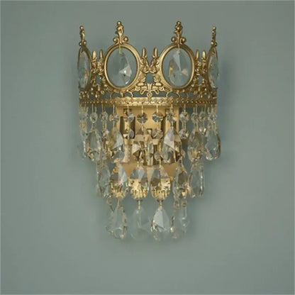 Gold-toned crown crystal chandelier wall sconce by decorbites featuring dangling crystal droplets for bedroom decor