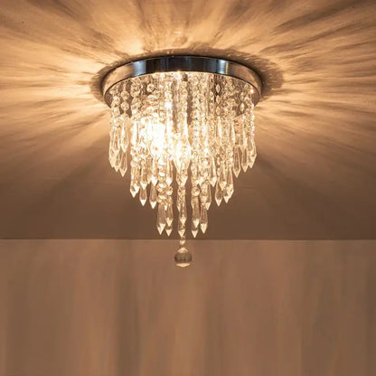 DecorBites crystal ceiling light with chrome base and cascading glass prisms emitting warm light for elegant home decor