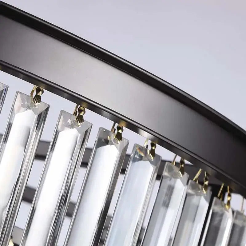 Clear crystal prisms hanging from a black metal frame with golden hooks in the decorbites crystal ceiling light