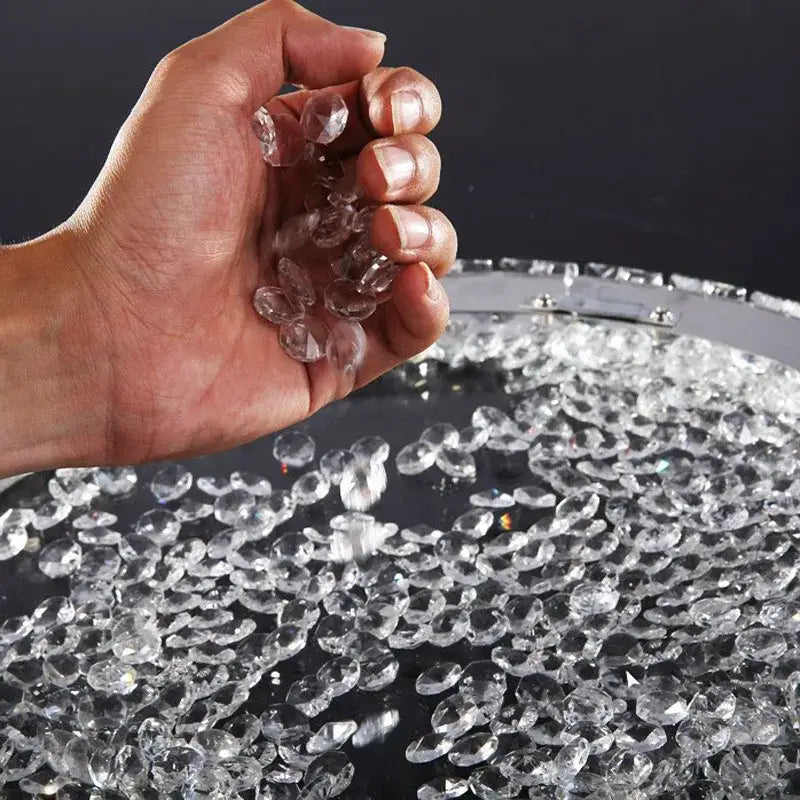 Hand holding clear faceted crystal beads for decorbites crystal ceiling light with LED bulbs for living room and bedroom use