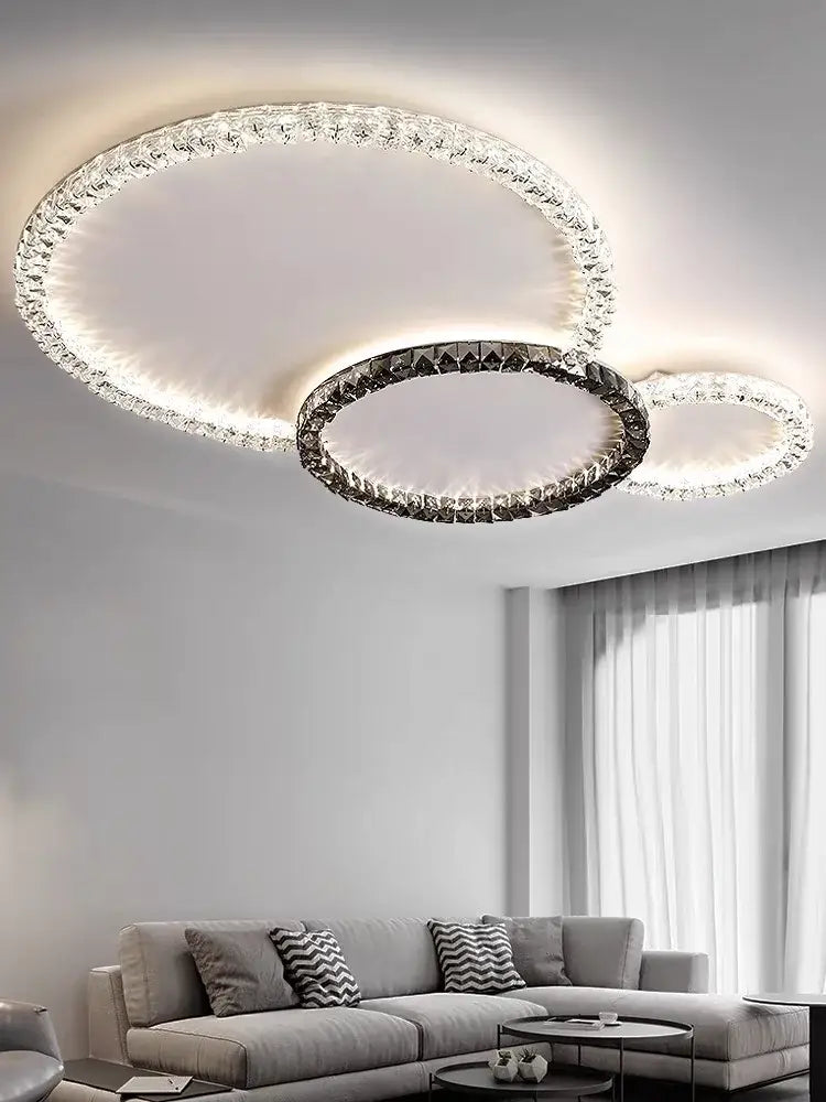 Modern decorbites crystal ceiling light with three interlocking rings featuring clear crystals and sleek metallic frame for living room