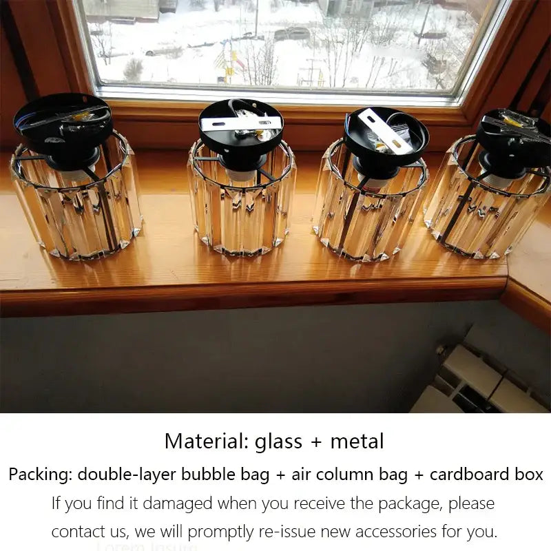 Four decorbites crystal ceiling lights with black metal tops and crystal glass shades on a wooden windowsill