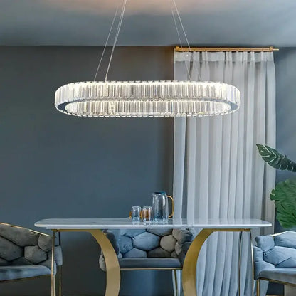 A modern oval-shaped decorbites crystal ceiling pendant chandelier with a sleek metallic frame for luxe room decor
