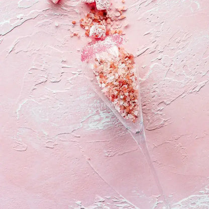 A clear elegant champagne flute filled with pink himalayan salt crystals from decorbites crystal champagne flutes set