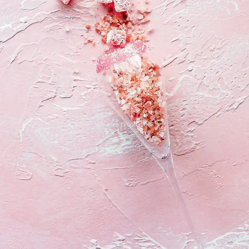 A clear elegant champagne flute filled with pink himalayan salt crystals from decorbites crystal champagne flutes set
