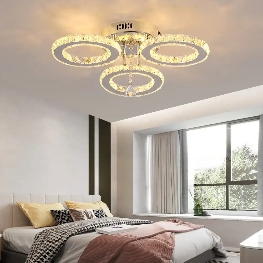 Modern decorbites crystal chandelier with three interlocking gold rings and central hanging crystal pendant for living room