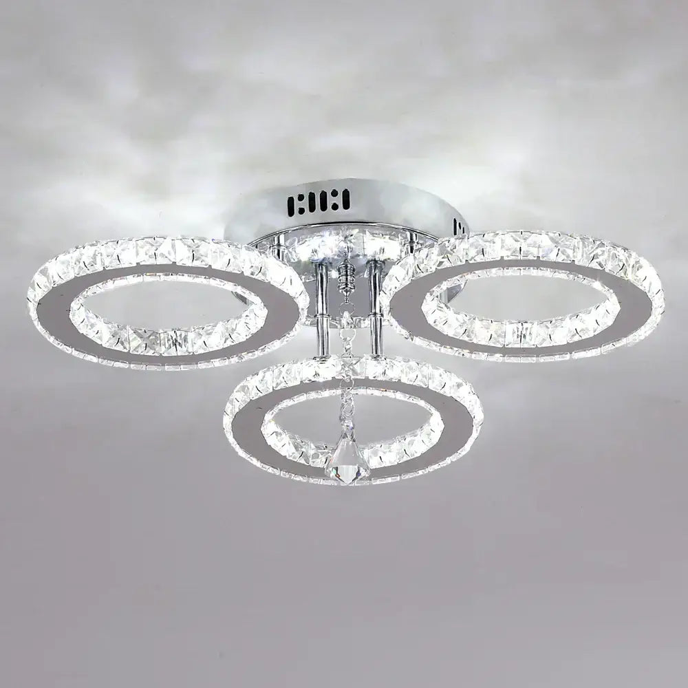 Modern chrome-finished decorbites crystal chandelier with three interlocking rings and central dangling crystal for living room