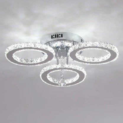 Modern chrome-finished decorbites crystal chandelier with three interlocking rings and central dangling crystal for living room