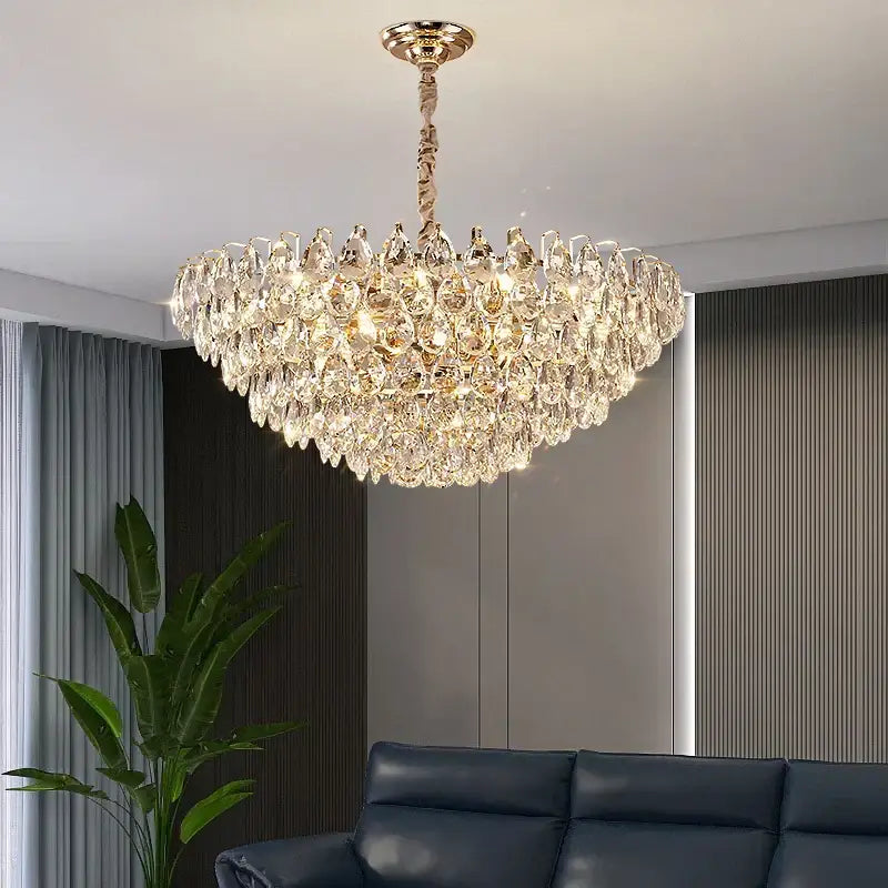 A luxurious gold-toned decorbites crystal chandelier ceiling light with cascading clear faceted crystals for living room use