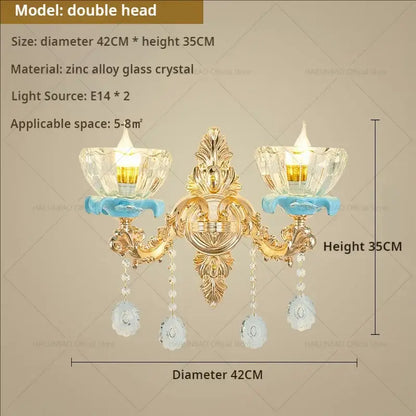 Gold-toned double-headed wall sconce with ornate metalwork and crystal glass shades from decorbites crystal chandelier collection