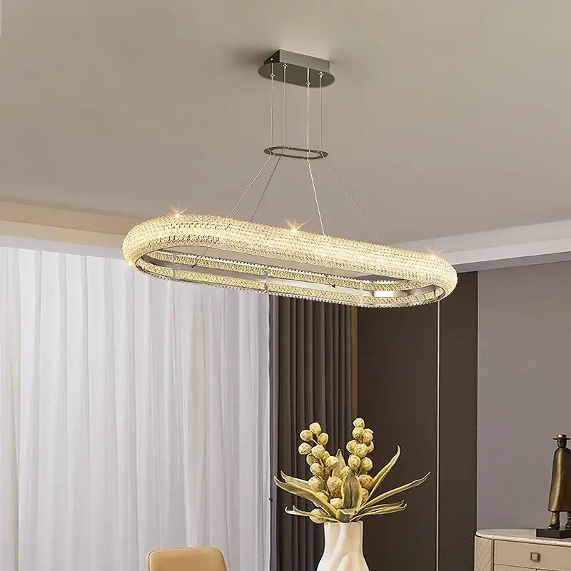 Modern luxury crystal chandelier by decorbites with a sleek chrome frame and embedded crystals emitting warm light