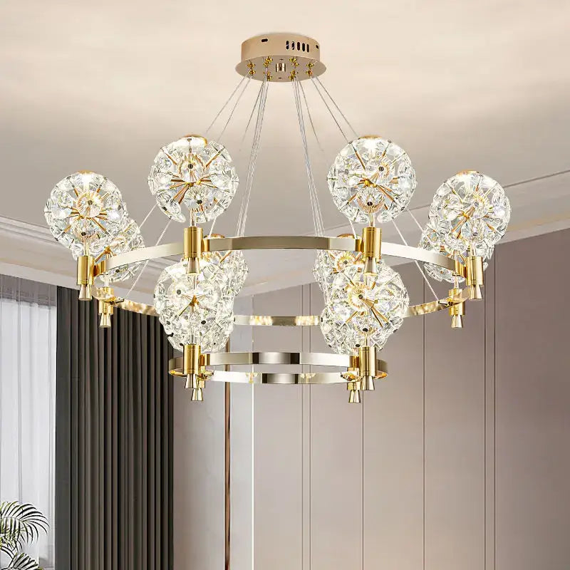 Gold-toned decorbites crystal chandelier with crystal dandelion spheres on circular metal frame for luxe living spaces
