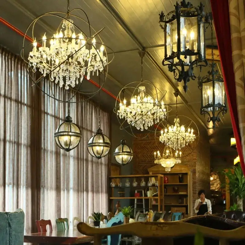 Crystal chandeliers with intricate metal frames hang in a rustic dining space featuring decorbites crystal chandelier