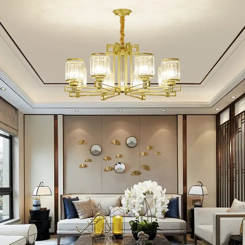 Gold-toned decorbites crystal chandelier with clear cylindrical glass shades and modern geometric frame for living spaces