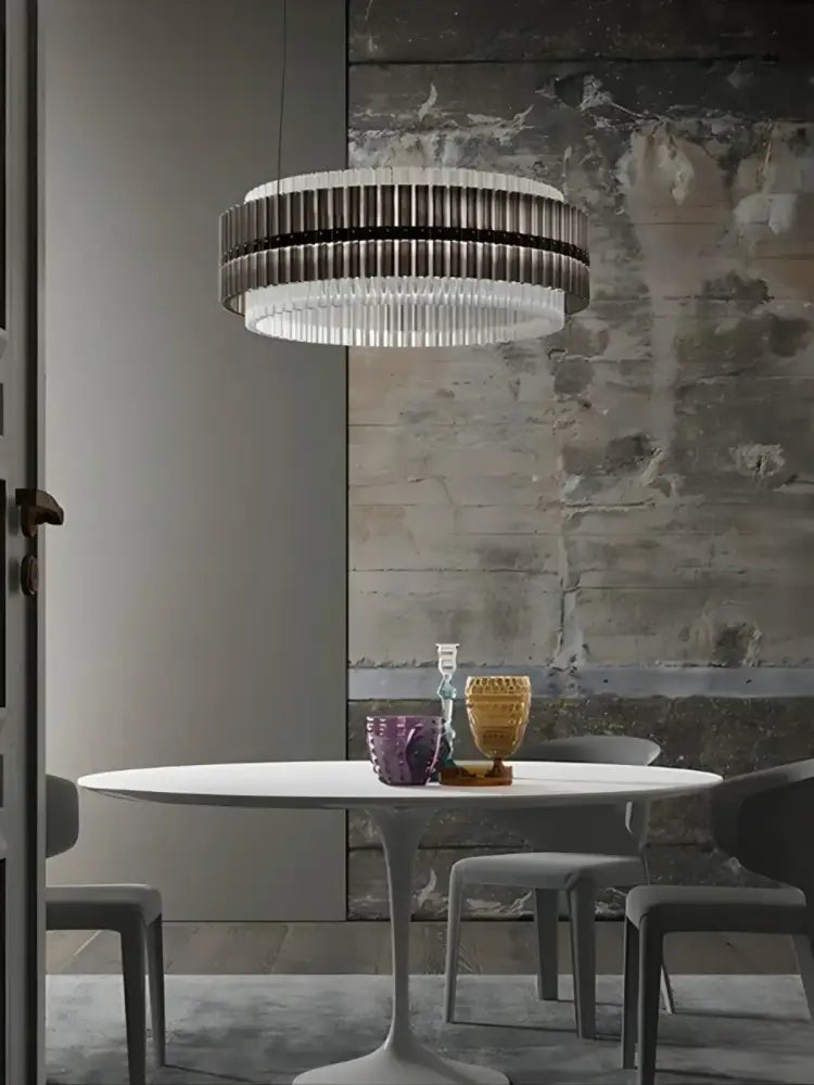 A decorbites crystal chandelier featuring a modern circular pendant design with dark and clear glass rods for elegant décor