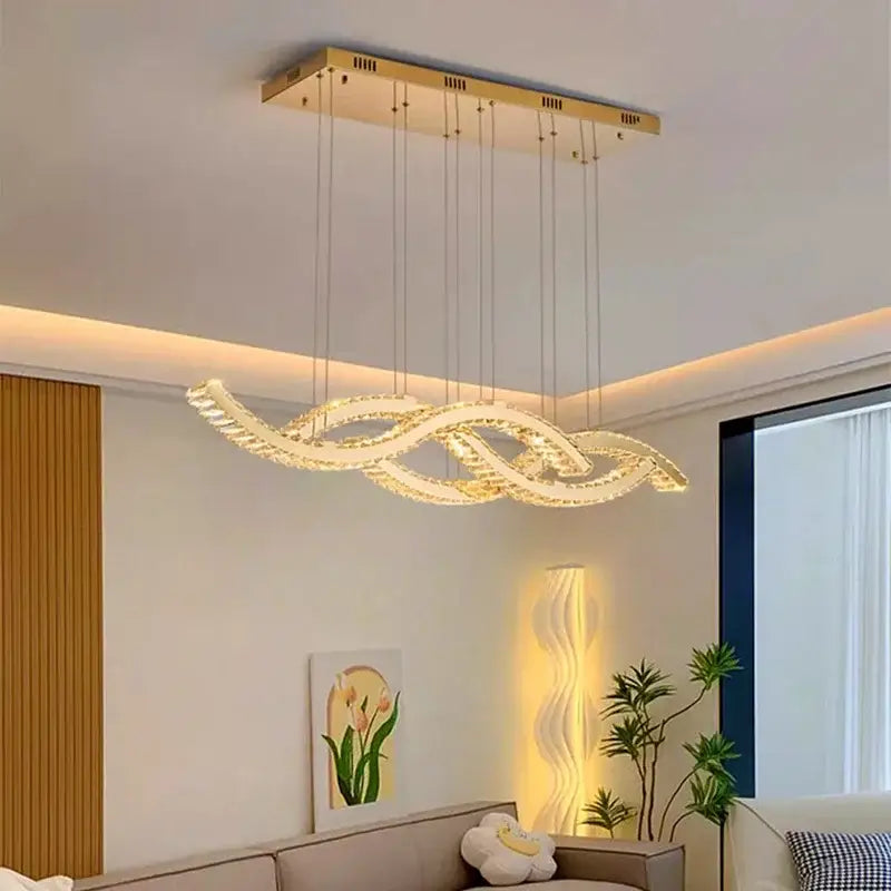 Gold-toned rectangular decorbites crystal chandelier pendant light with flowing crystals emitting warm ambient light