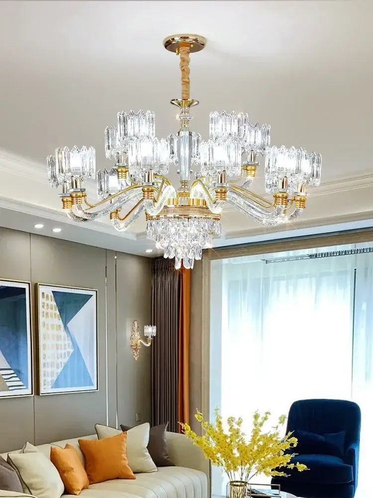 A luxurious gold-toned decorbites crystal chandelier with multiple tiers of clear crystal prisms for elegant lighting
