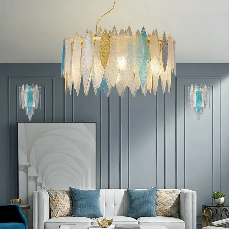 A modern decorbites crystal chandelier with cascading translucent glass leaf shades in gold and blue for elegant interiors