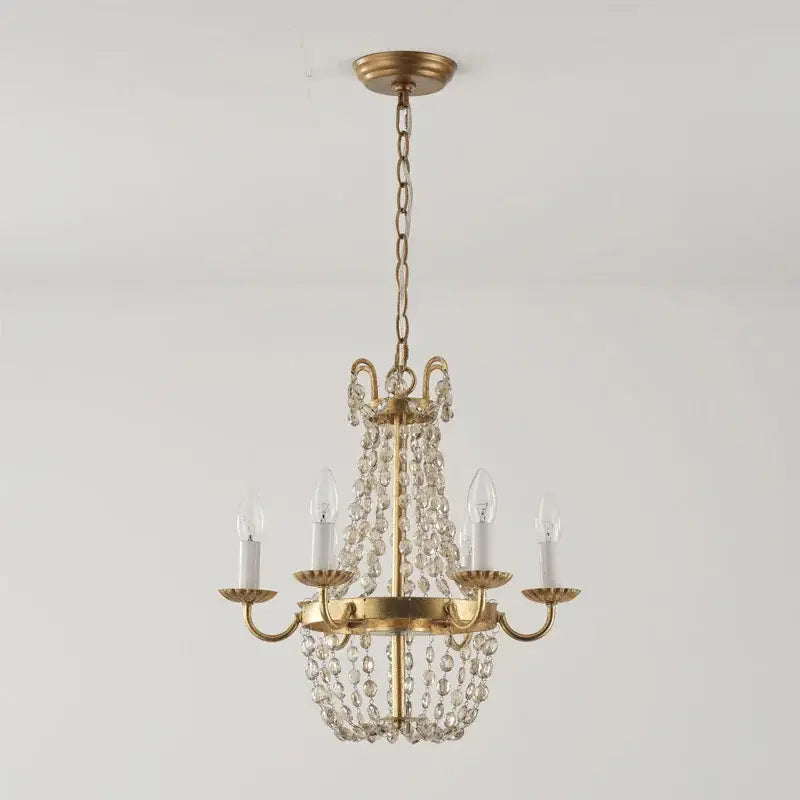 A gold-toned decorbites crystal chandelier with clear crystal beads and five candle-style bulbs for elegant lighting