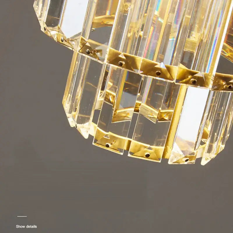 A decorbites crystal chandelier with clear faceted crystal prisms and gold-toned metal brackets for elegant living spaces