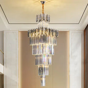 A multi-tiered decorbites crystal chandelier with cascading clear and frosted glass rods and gold-toned chain suspension