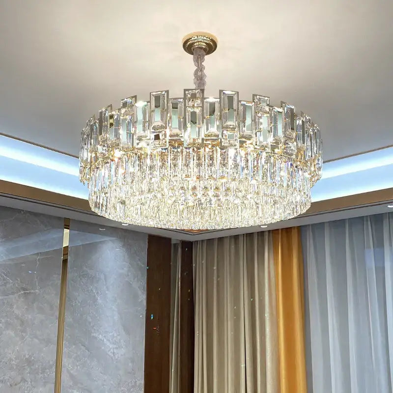 A multi-tiered decorbites crystal chandelier with clear faceted glass prisms and gold-toned ceiling mount for elegant lighting