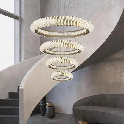 A modern DecorBites crystal chandelier with cascading clear crystal rings and gold-toned metal for living and dining rooms