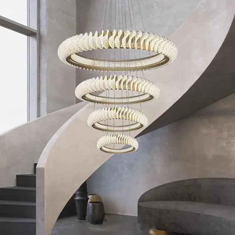 A modern DecorBites crystal chandelier with cascading clear crystal rings and gold-toned metal for living and dining rooms