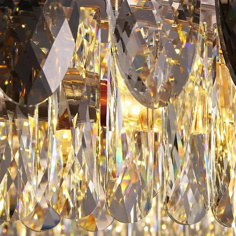 A sparkling DecorBites crystal chandelier pendant light with faceted teardrop and geometric prisms catching golden light