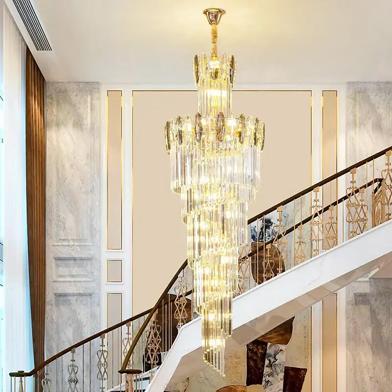 A multi-tiered gold-toned decorbites crystal chandelier hangs elegantly above a minimalist duplex staircase