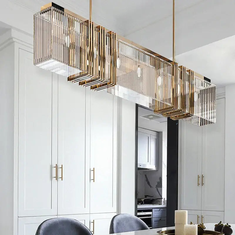 Gold-toned decorbites crystal chandelier featuring vertical crystal prisms and exposed bulbs for elegant interior decoration