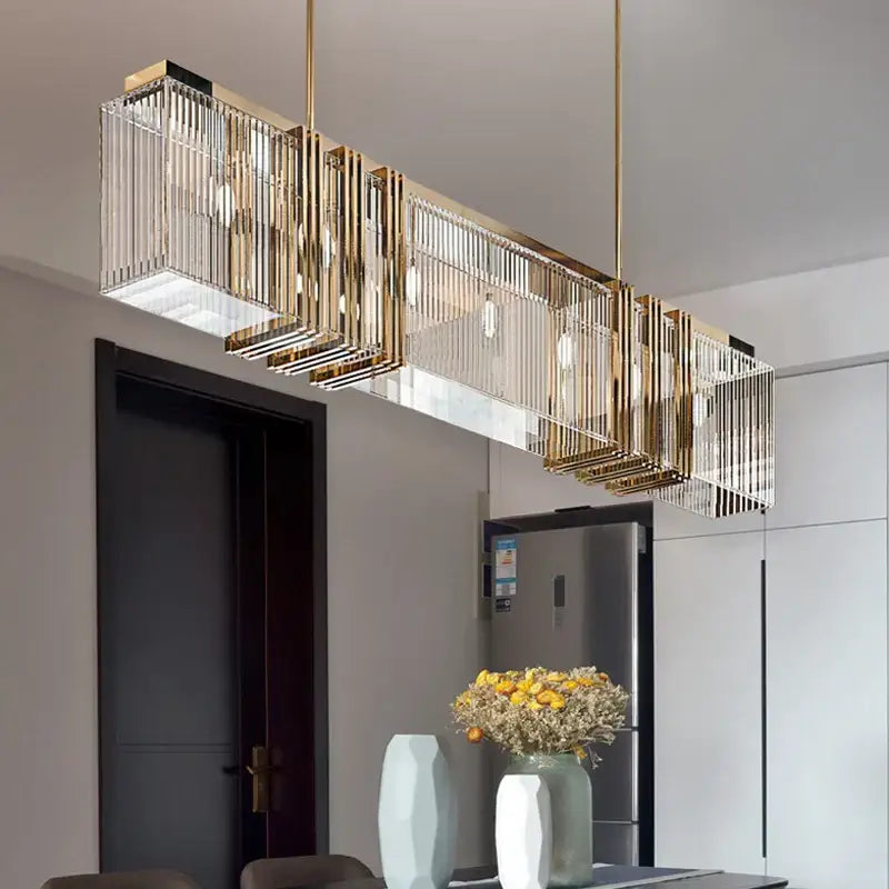 Gold-toned decorbites crystal chandelier with vertical crystal rods and exposed bulbs for elegant interior decoration