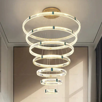 A modern DecorBites crystal chandelier with concentric rings, clear crystals, and teal-blue accents for elegant spaces