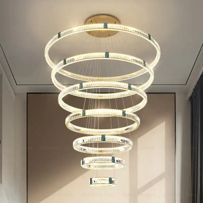 A modern DecorBites crystal chandelier with concentric rings, clear crystals, and teal-blue accents for elegant spaces
