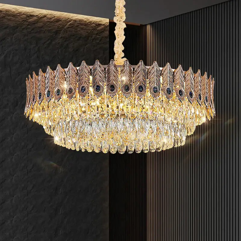 Decorbites crystal chandelier featuring golden peacock feather design with cascading teardrop crystals and dark blue gemstones