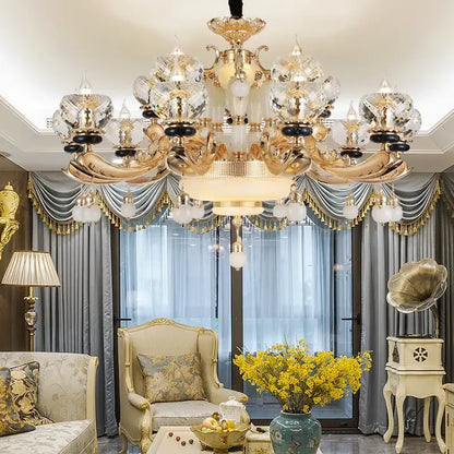 Gold-toned decorbites crystal chandelier with intricate ornate detailing and multiple tiers for living dining and bedroom