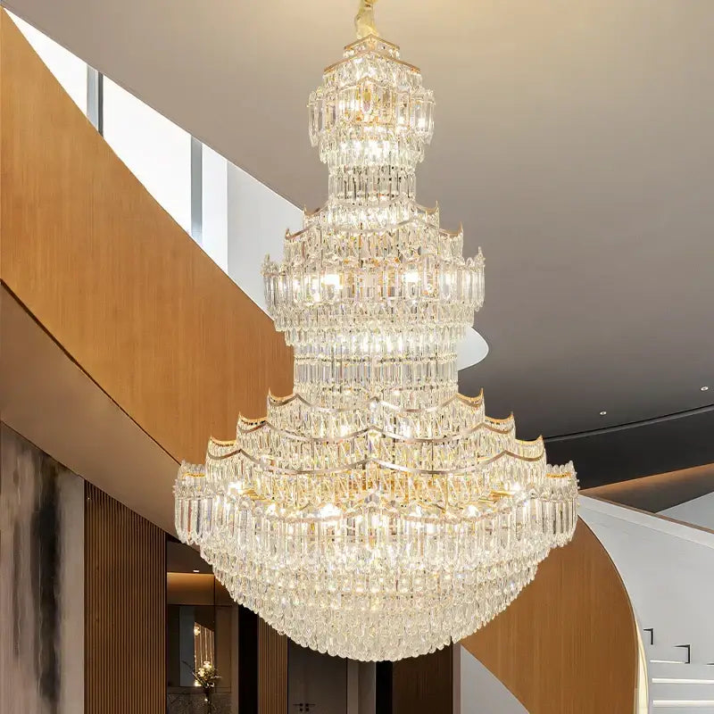 A multi-tiered decorbites crystal chandelier with gold-toned accents and cascading faceted crystals for villa lobbies