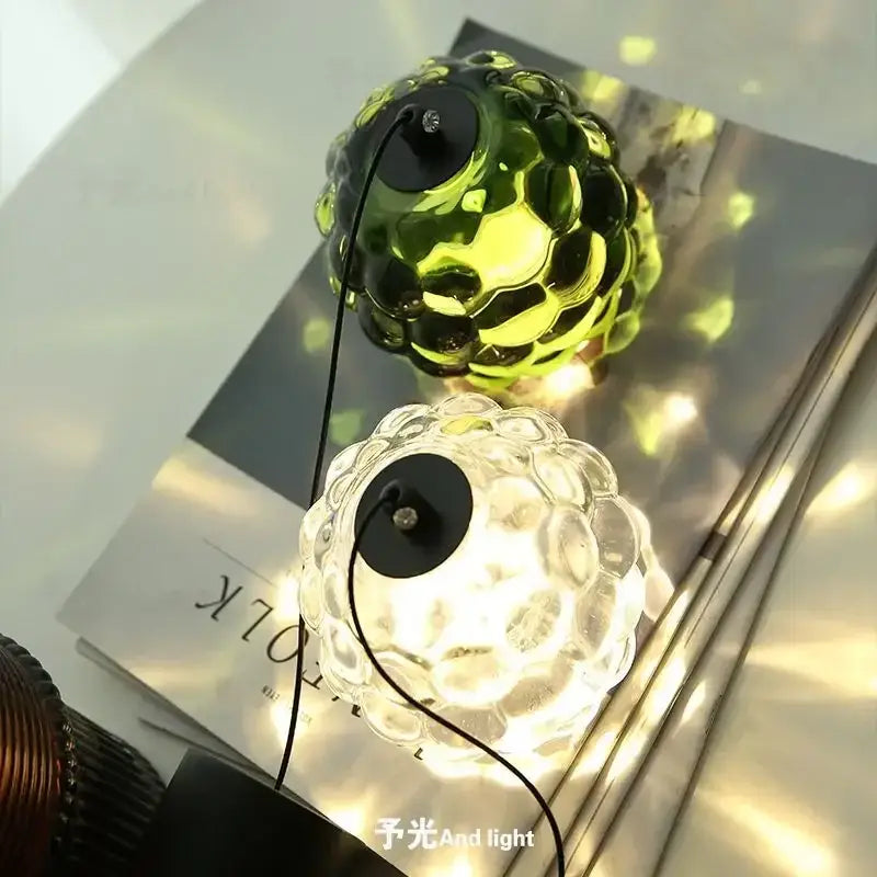 Two spherical glass table lamps with bubble texture in translucent green and clear on black bases for decorbites crystal chandelier