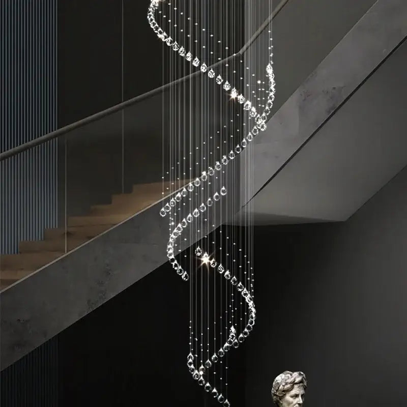 A modern decorbites crystal chandelier with clear crystal beads and metallic chains above a staircase for high ceilings