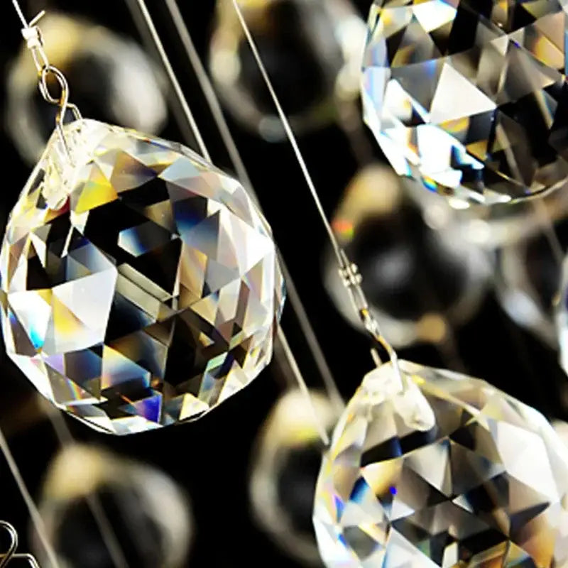 Clear faceted crystal spheres hanging from thin wires in decorbites crystal chandelier for high ceilings living room