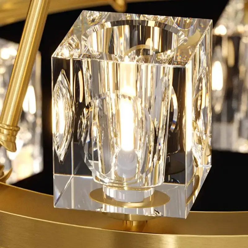 Decorbites crystal chandelier featuring a clear faceted crystal cube pendant with gold-toned metallic accents for dining room lighting