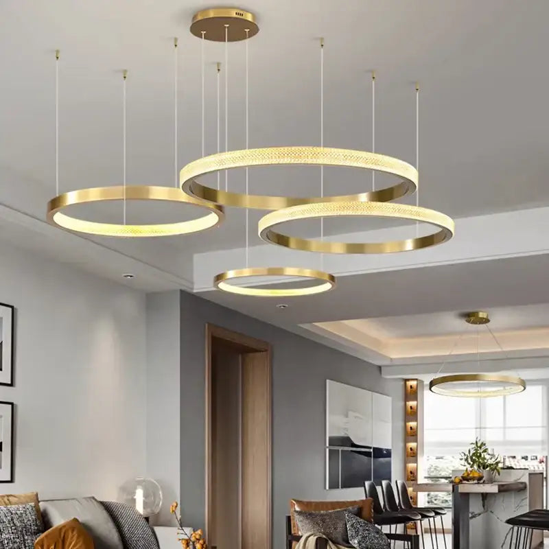 Modern gold-toned circular pendant lights with textured illuminated rings in decorbites crystal chandelier for living room