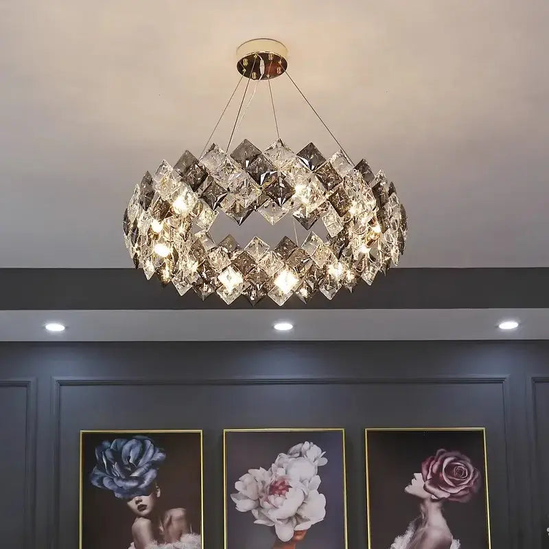 A modern decorbites crystal chandelier with faceted crystals in overlapping rings illuminated by warm light