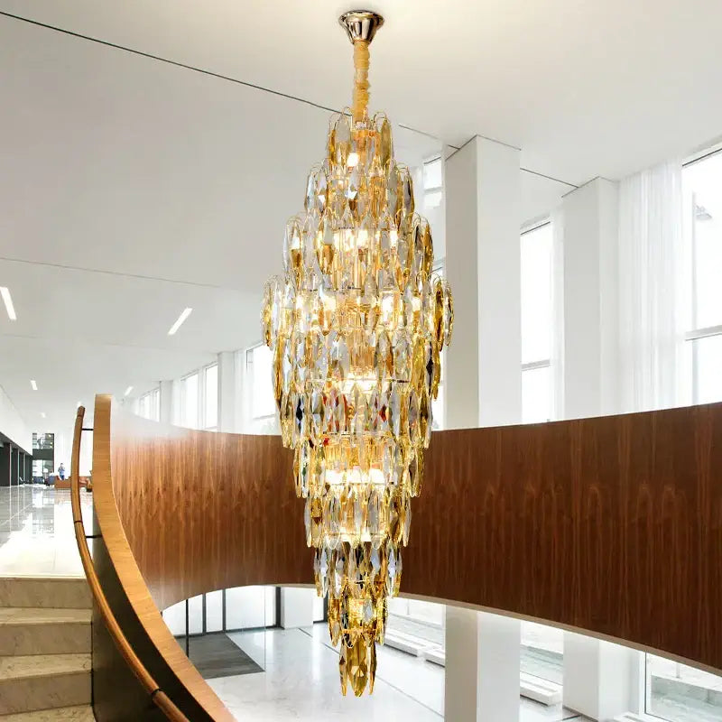 DecorBites crystal chandelier features a multi-tiered polished brass fixture with cascading golden and clear crystal prisms