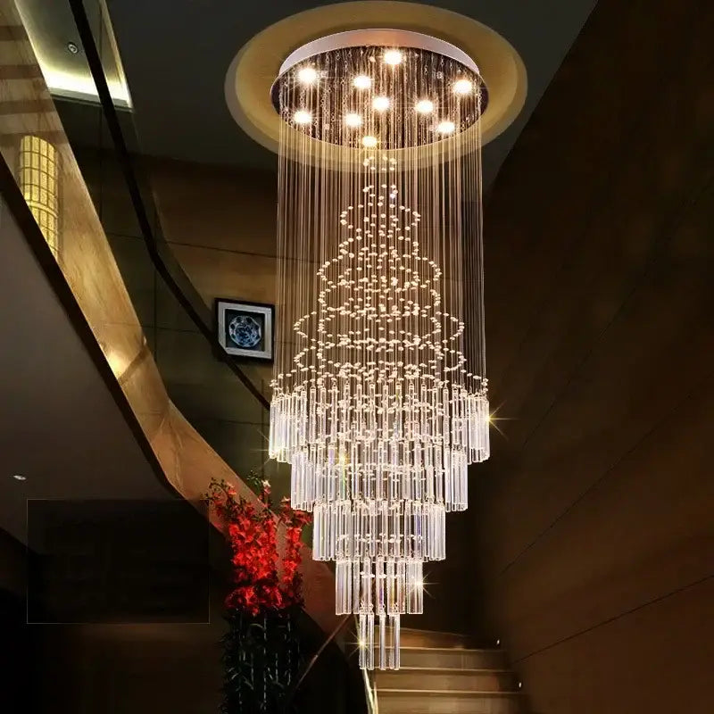 A modern multi-tiered DecorBites crystal chandelier with cascading glass rods and LED lighting for staircase use