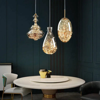 Three elegant glass pendant lights with golden accents and fairy lights in a decorbites crystal chandelier for dining room